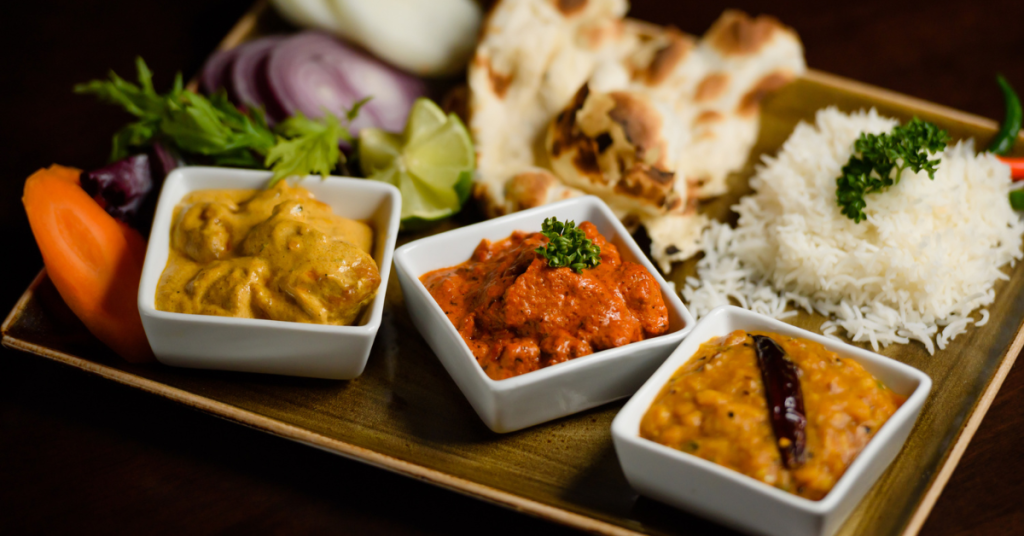 An image showcasing a diverse spread of dishes at an Indian buffet, illustrating the variety and vibrancy of the offerings.