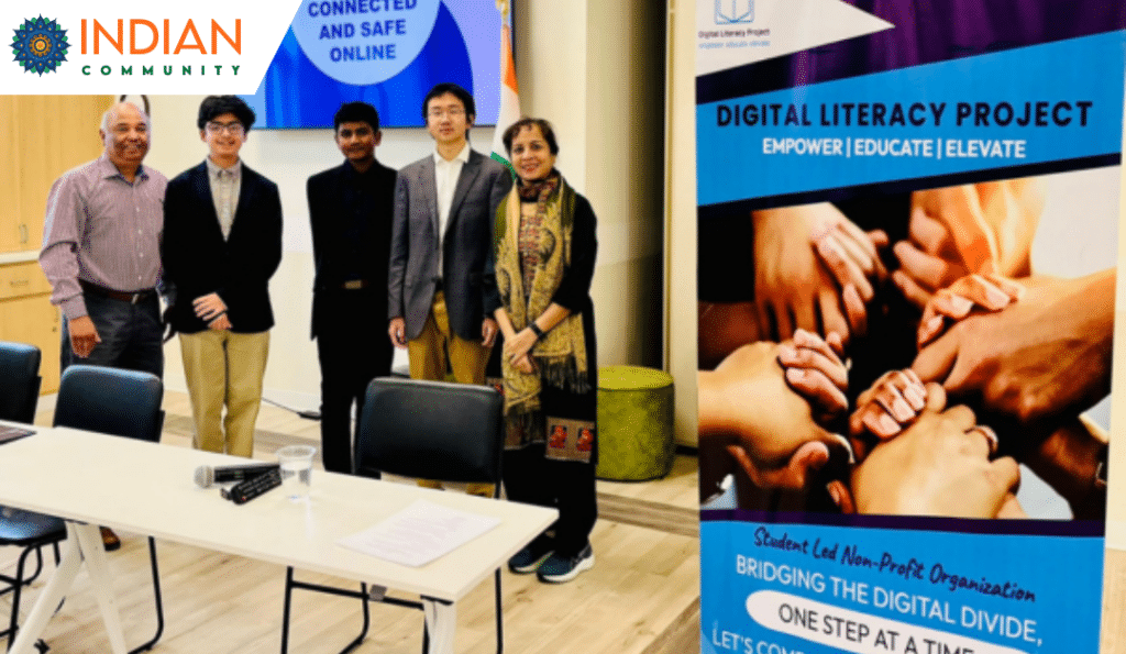 Group photo of five individuals standing in front of a presentation screen and a banner for the Digital Literacy Project.