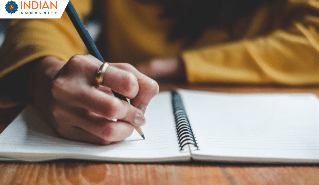 A person writing in a spiral-bound notebook