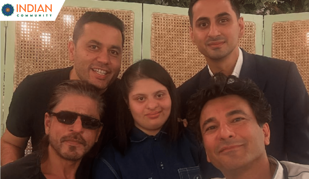 group photo featuring Vikas Khanna, a young girl and others, including Shah Rukh Khan in sunglasses, smiling together