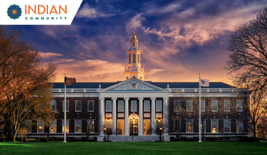 An elegant university building with grand columns, set against a stunning sunset sky.