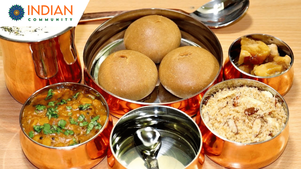 Traditional Dal Baati Churma served on a platter with ghee, dal, and churma alongside pickle and salad.