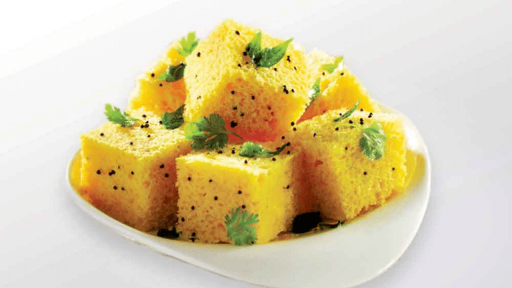 Soft and spongy dhokla garnished with coriander and coconut.