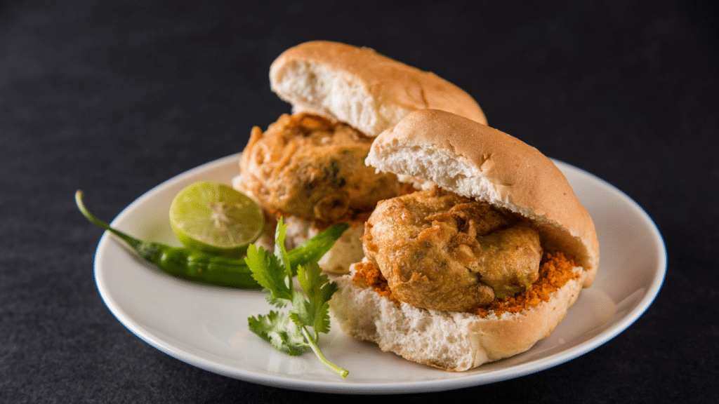 Vada Pav served with fried green chilies and dry garlic chutney.