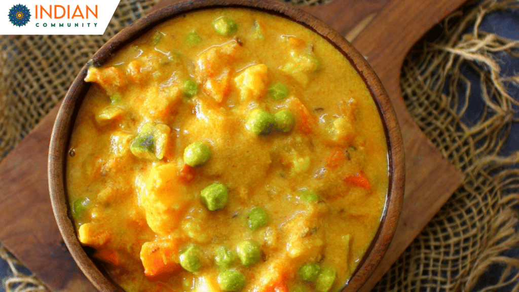 Creamy vegetable korma served in a bowl with naan bread on the side